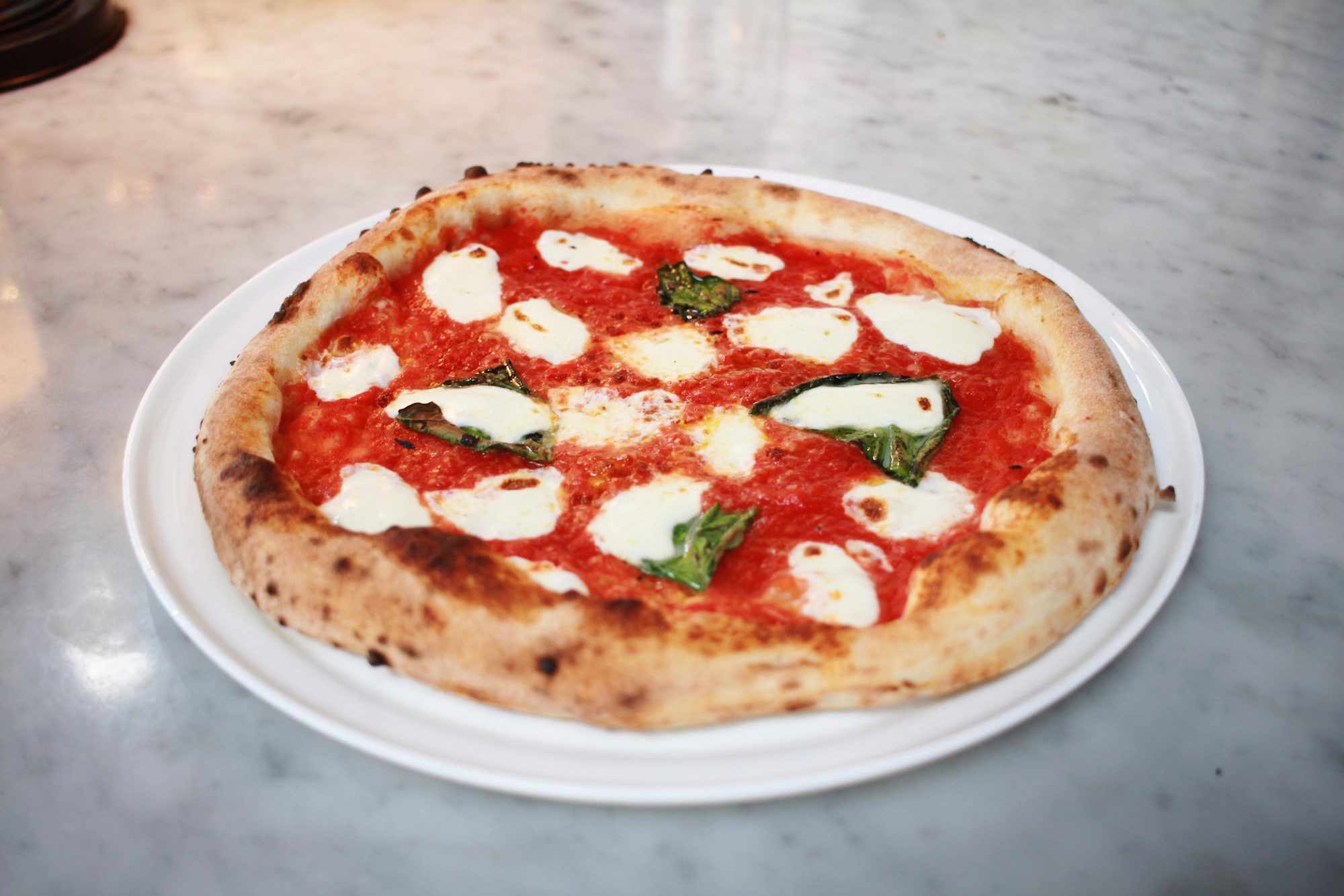 A wood-fired Margherita on a marble table